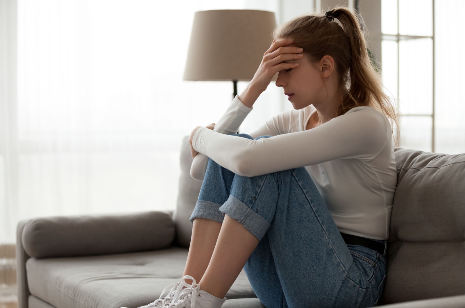 traurige Frau sitzt auf der Couch