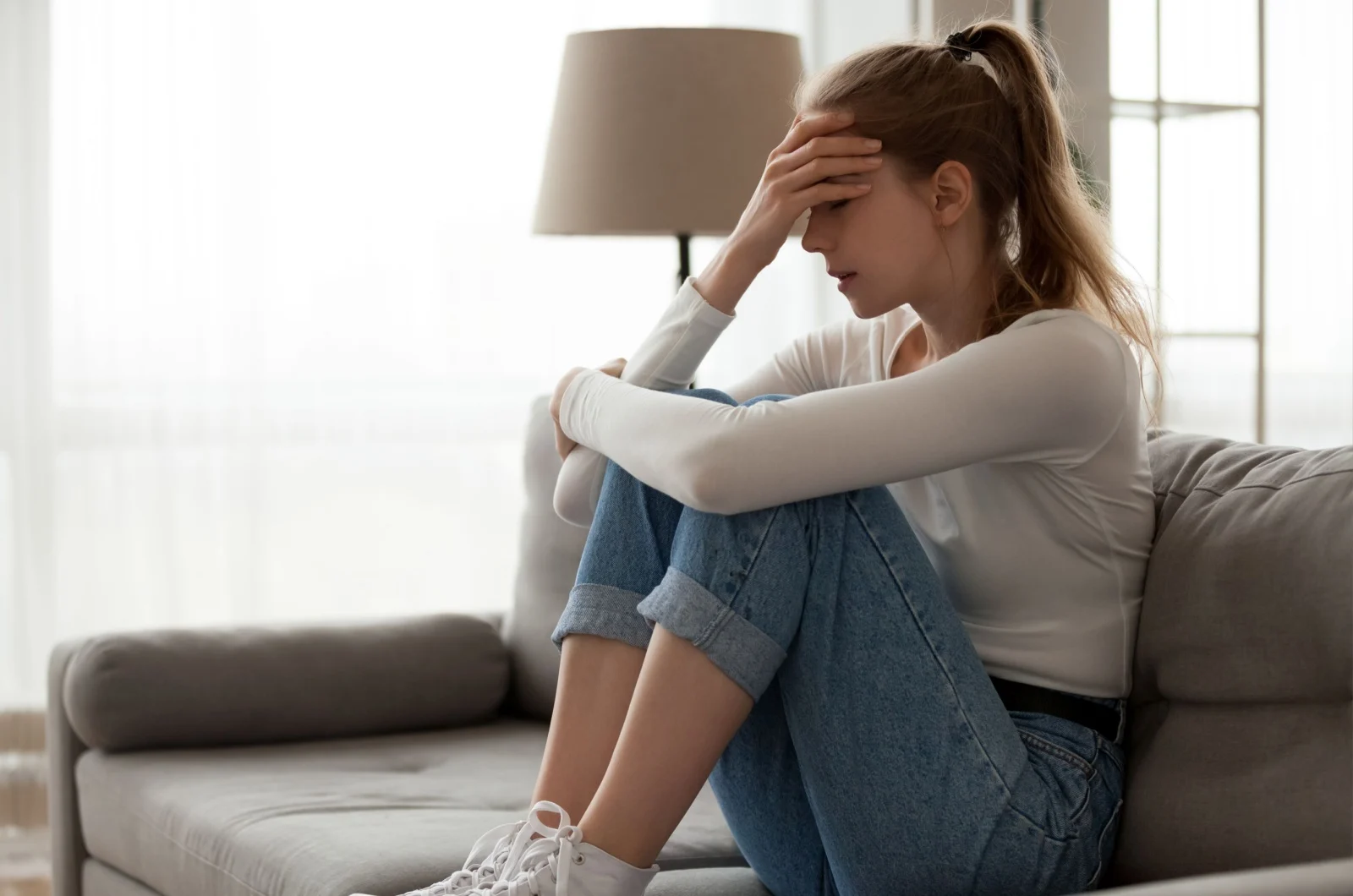 traurige Frau sitzt auf der Couch