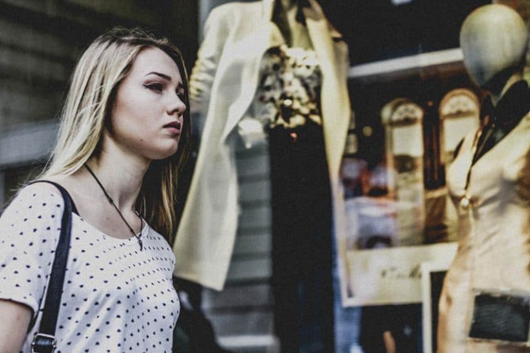 Das Mädchen geht am Boutique-Fenster vorbei