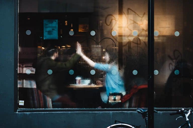 Zwei junge Leute sitzen in einem Café und werfen einen Knochen