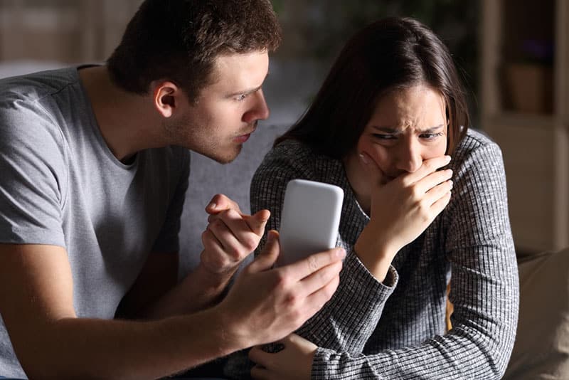 eifersüchtiger Mann zeigt Telefon zur Frau