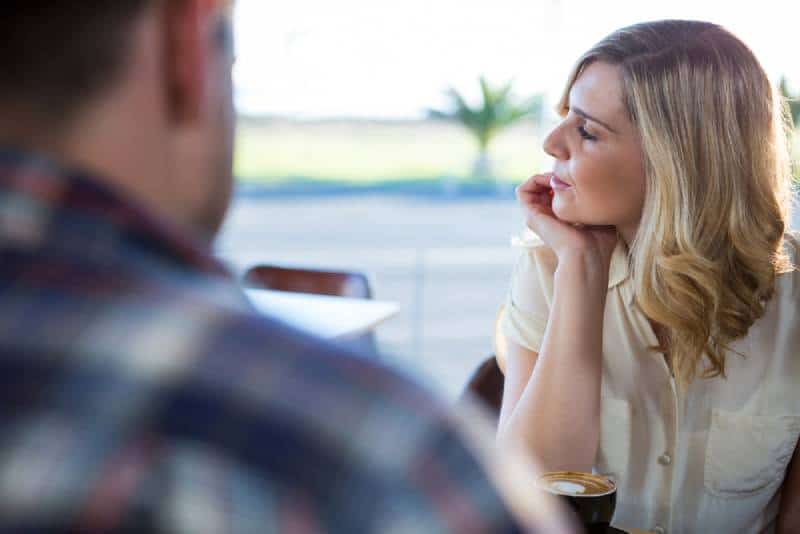verärgerte Frau schaut weg, während sie mit Mann sitzt