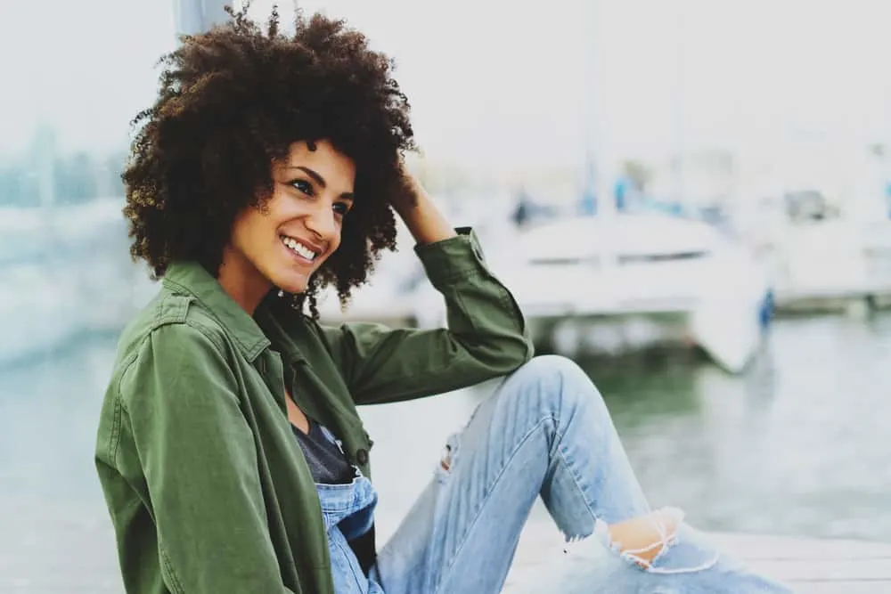 Eine Frau mit einer Afro-Frisur sitzt auf dem Dock