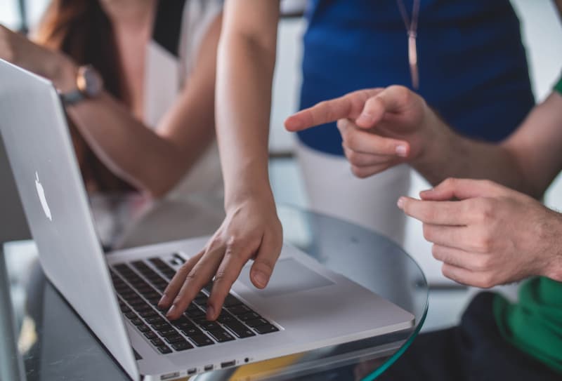 Person, die das MacBook Pro berührt und darauf zeigt
