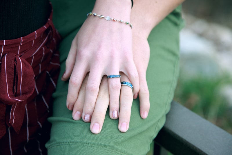 das Mädchen, das ihre Hand über das Bein ihres Freundes legte
