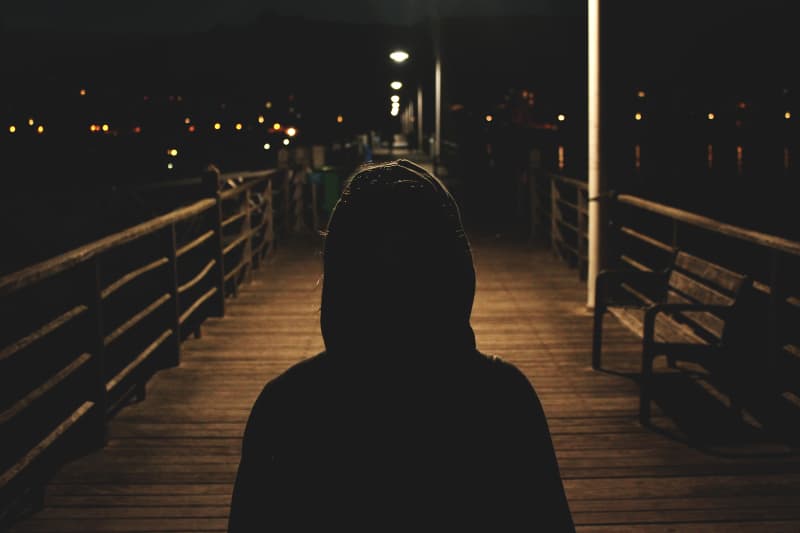 ein Mädchen mit Kapuze allein im Dunkeln