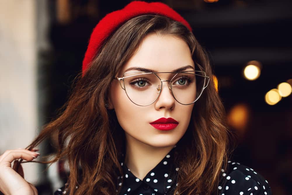 ein Porträt einer schönen Frau mit rotem Lippenstift und Brille