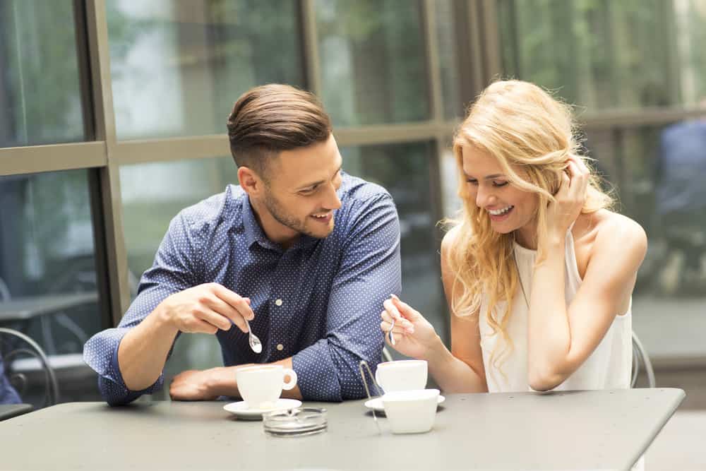 ein verliebtes Paar, das beim Kaffee lacht