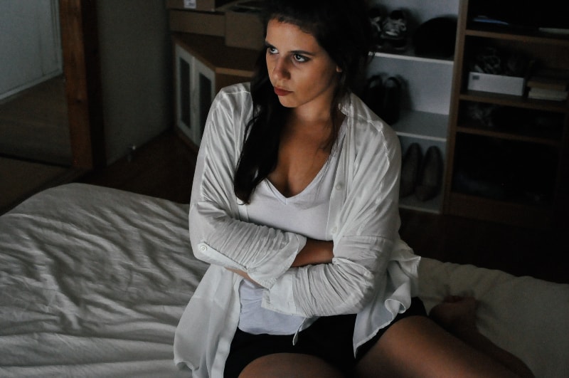 wütendes Mädchen sitzt auf dem Bett