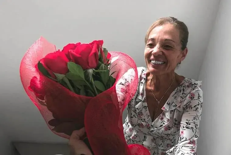 aeltere Frau mit Rosenstrauss