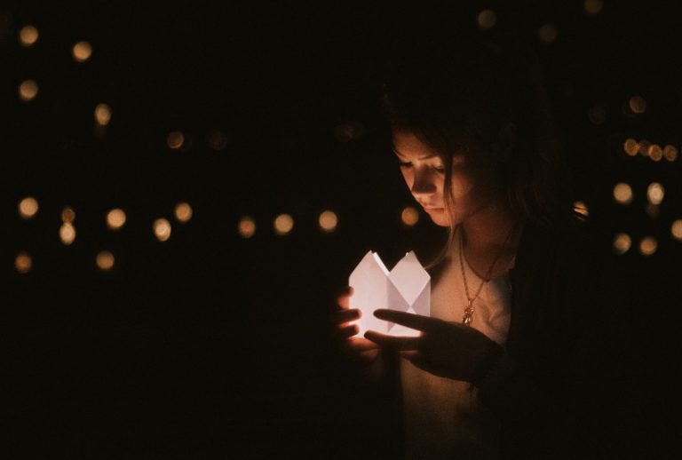 Das Mädchen hält eine Kerze in der Hand