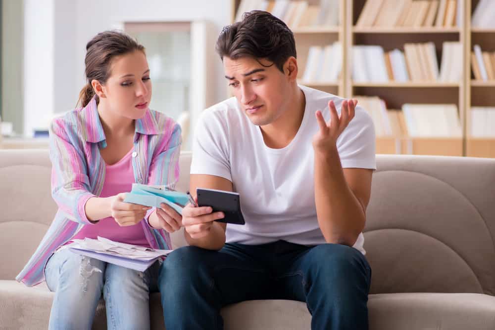 Ein Mann und eine Frau sitzen auf der Couch und zählen etwas