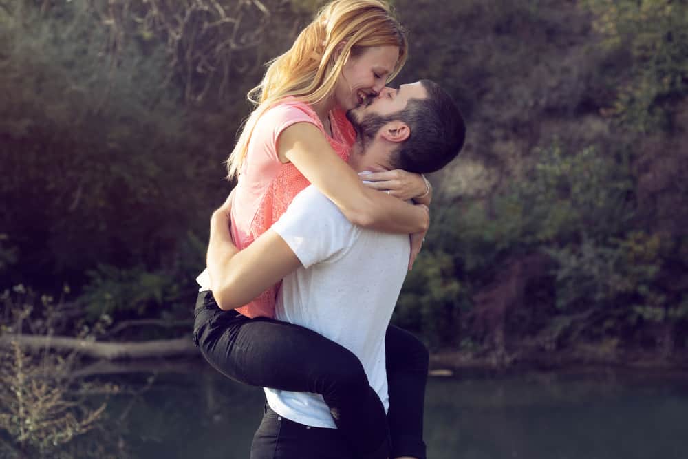 Ein junges Liebespaar am Fluss küsst sich