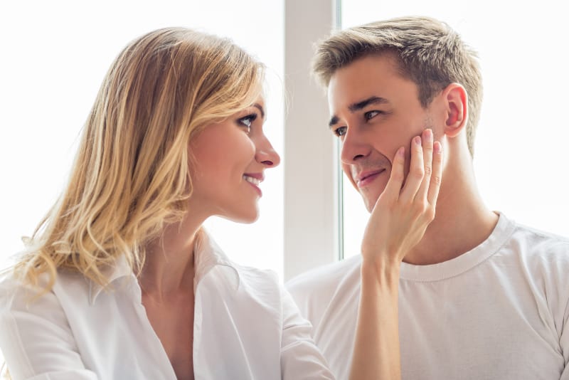 Ein junges Mädchen berührt das Gesicht ihres Freundes