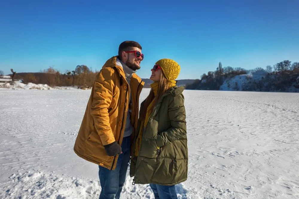 Draußen im Schnee steht ein liebevolles Paar und redet