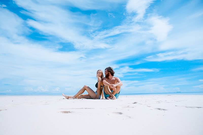 Frau und Mann sitzen am Strand