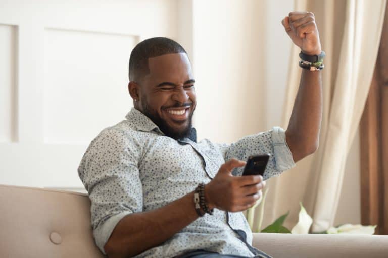Mann Gewinner hält Smartphone