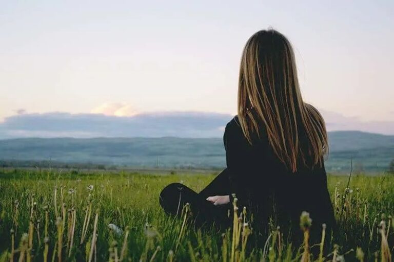 Frau sitzt im Gras