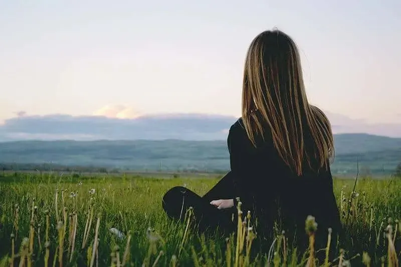 Frau sitzt im Gras