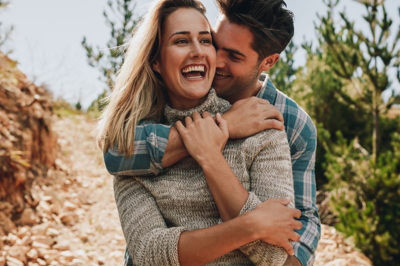 Ein gutaussehender Mann umarmt ein lachendes Mädchen