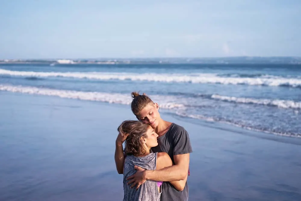 Ein liebevolles Paar in einer Umarmung steht am Meer