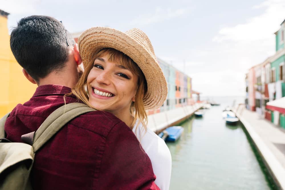 eine lächelnde Frau in den Armen eines Mannes in Venedig