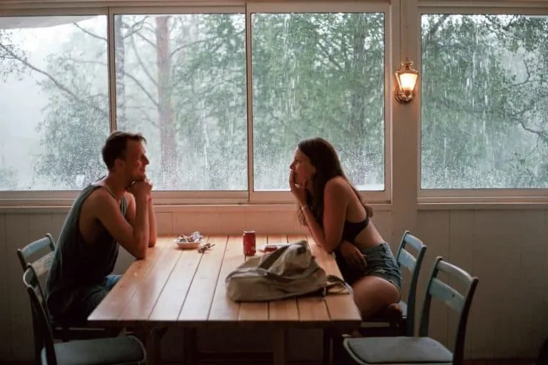 Ein Paar sitzt an einem Fenster in einem Restaurant und redet
