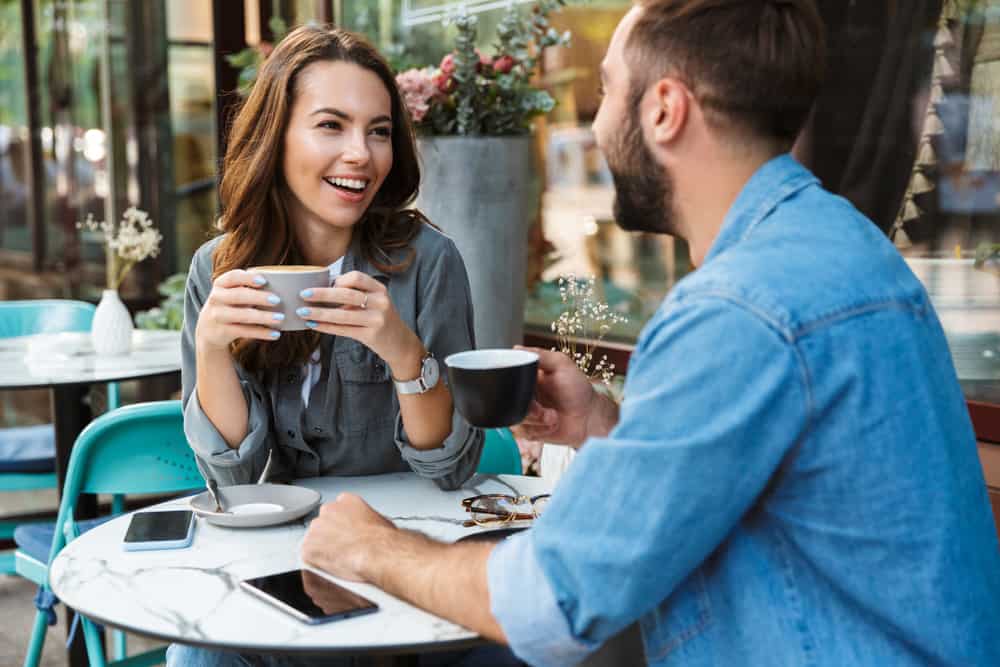 Ein Mann und eine Frau auf der Terrasse eines Cafés trinken Kaffee