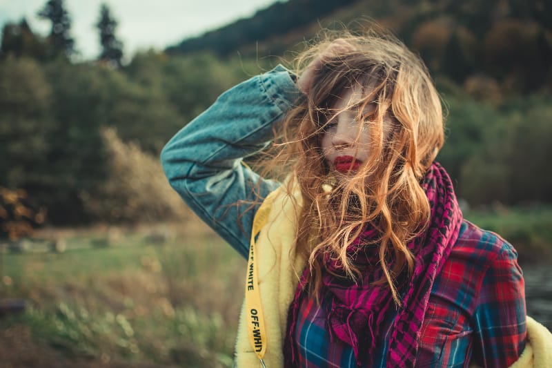 Frau in karierter Bluse und blauer Jeansjacke