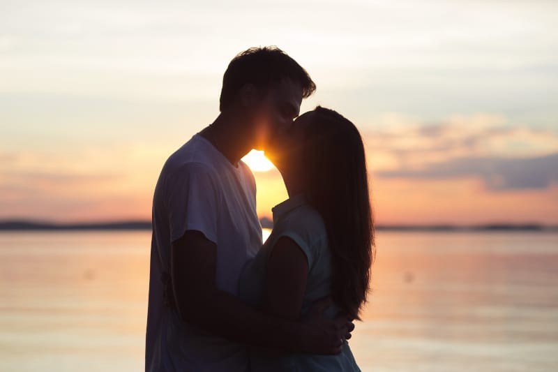 Liebespaar, das bei Sonnenuntergang küsst