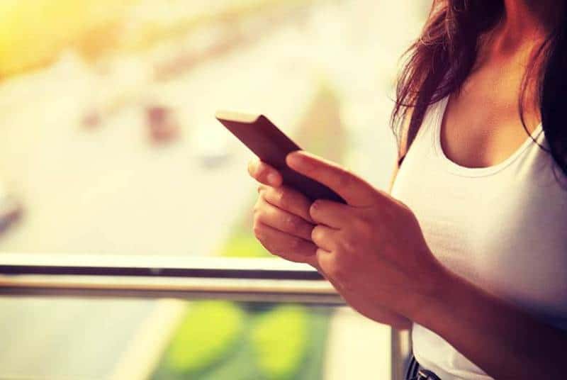Nahaufnahme flacher Fokus auf Frau, die ihr Telefon hält