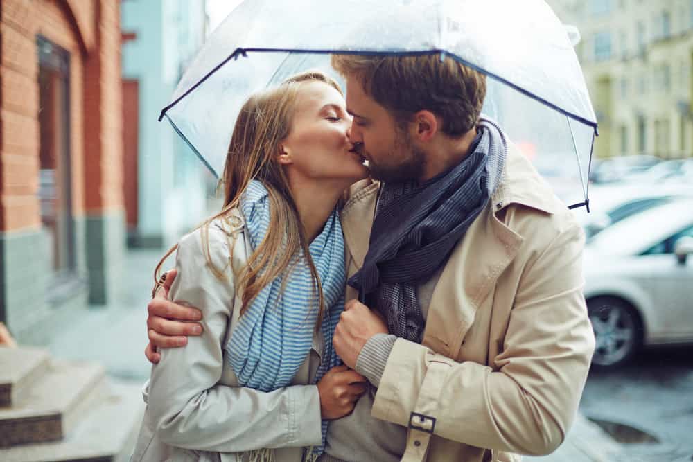 ein liebendes Paar, das sich im Regen küsst