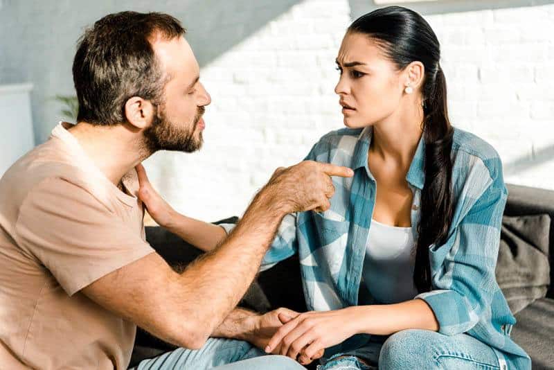 verrückter Mann, der Finger auf Frau zeigt