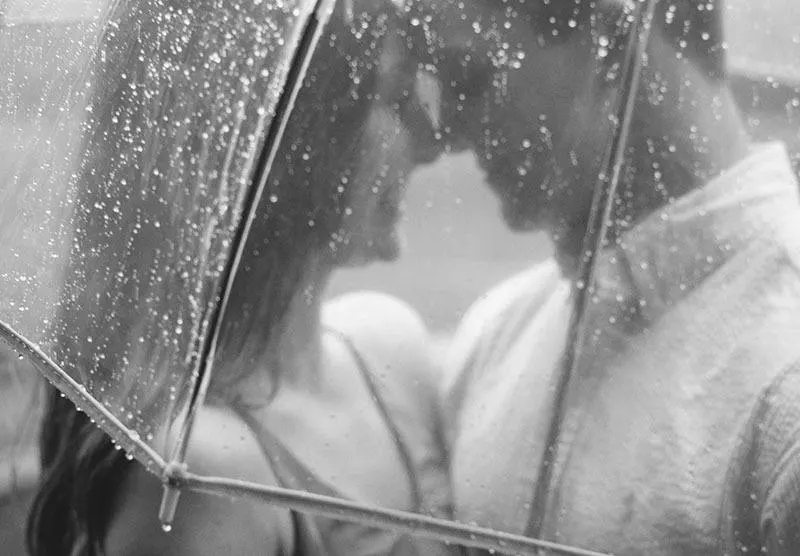 Ein glückliches Liebespaar steht unter einem Regenschirm