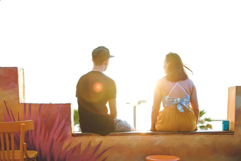 Ein liebevolles Paar sitzt auf der Terrasse und schaut in die Sonne