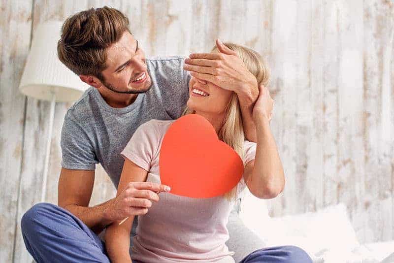 Ein lächelnder Mann gibt seiner Frau ein Herz