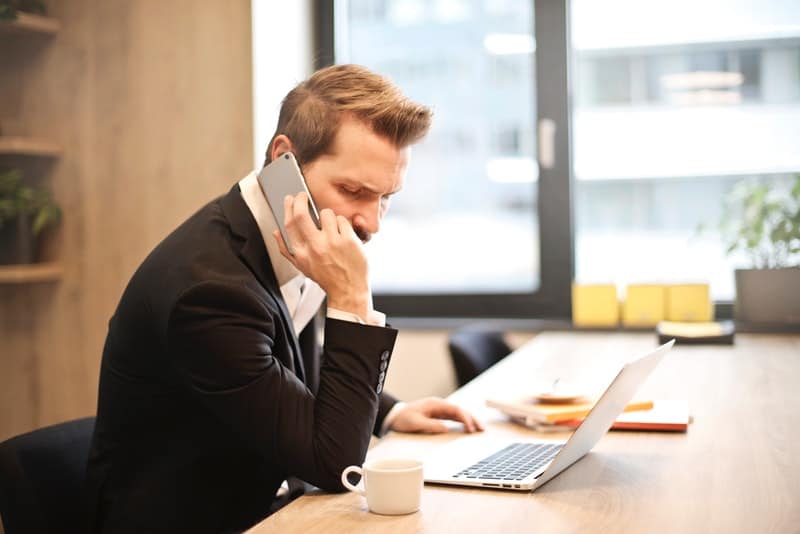 Mann im Büro spricht auf dem Handy
