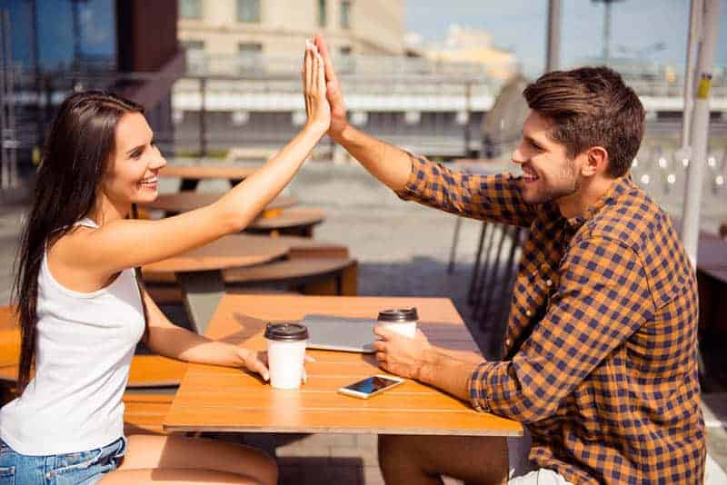 Mann und Frau High Five im Straßencafé