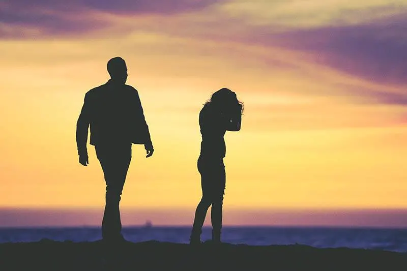 Silhouette eines Mannes und einer Frau bei Sonnenuntergang streiten