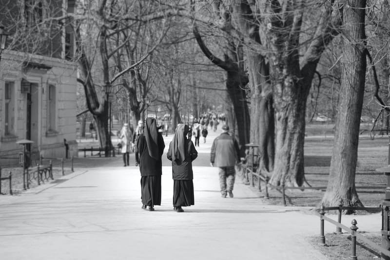 Zwei Nonnen gehen die Straße entlang und unterhalten sich