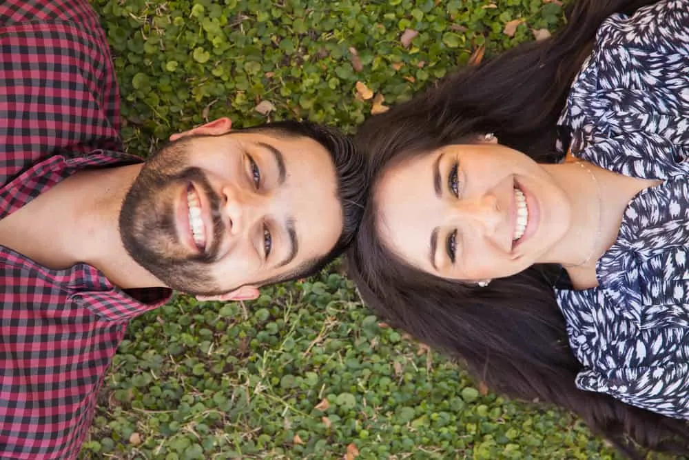 ein Mann mit Bart und eine Frau im Gras liegen