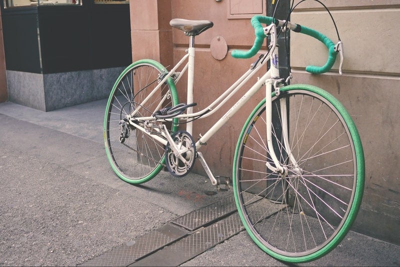 ein altes grünes Fahrrad an eine Wand gelehnt