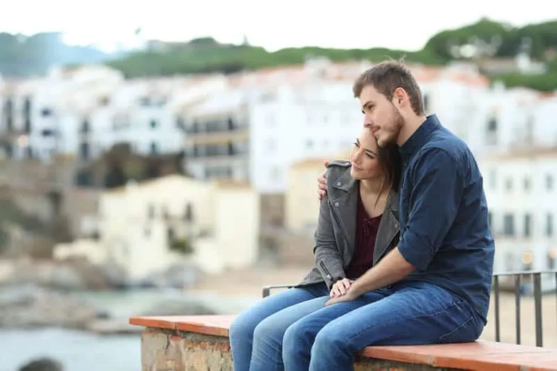 ein verliebtes Paar sitzt auf einem Betonzaun