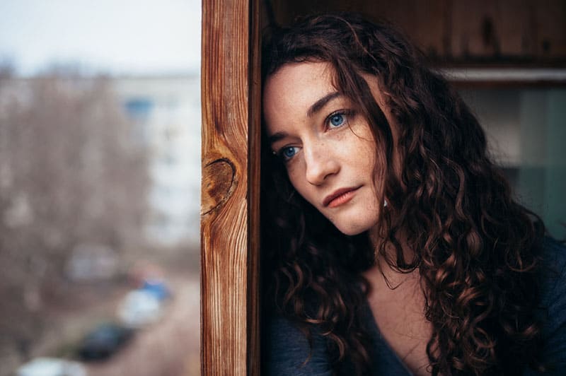 traurige Frau, die nach draußen schaut