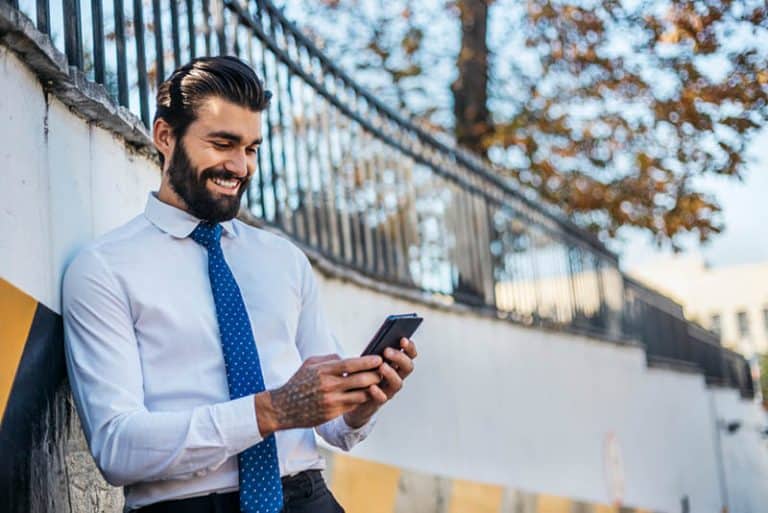Ein Mann im Anzug hält ein Handy in den Händen