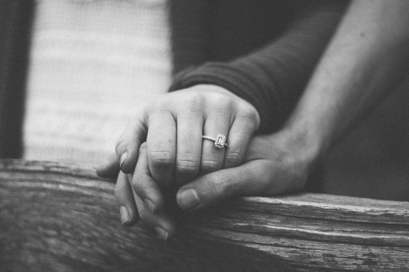 Graustufenfotografie eines Paares, das Hände hält