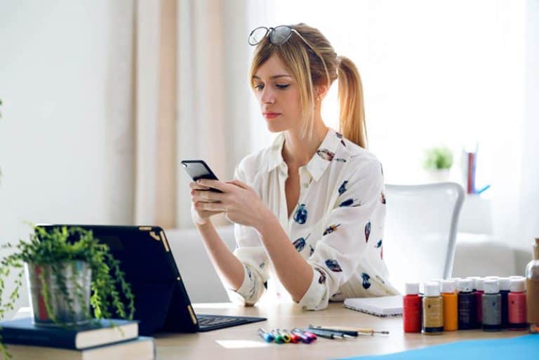 ein Mädchen sitzt im Büro und einen Schlüssel auf ihrem Handy