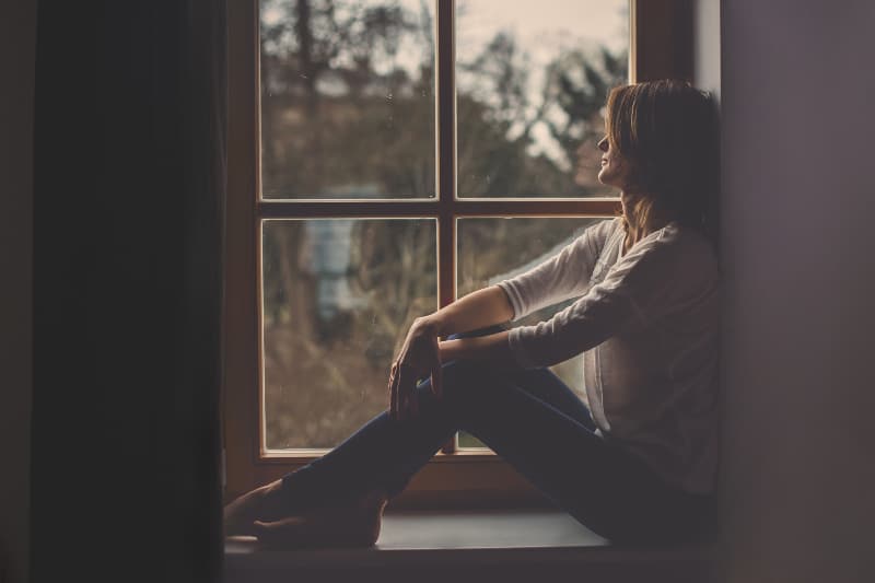 ein attraktives Mädchen sitzt am Fenster