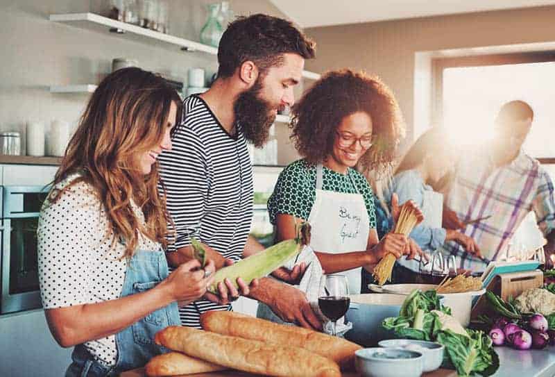 Eine Gruppe von Menschen in der Küche bereitet eine Mahlzeit zu
