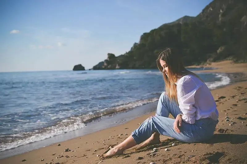 Traurige Frau sitzt am Strand